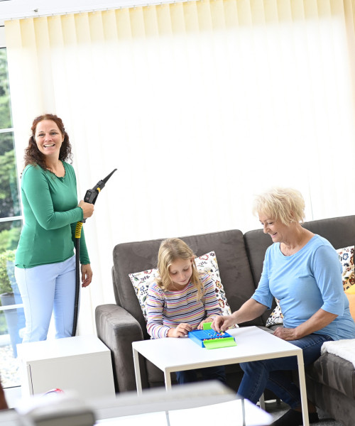 Happy family in the conservatory while mum cleans the louvre curtain with Thermostar dry steam